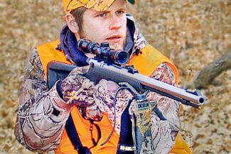 man outdoors on a hunt with a muzzleloader