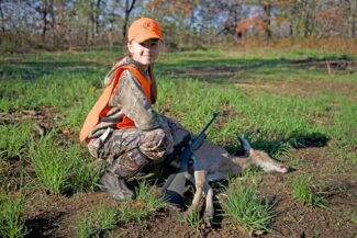 youth with deer after a hunt