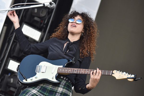 Naomi McPherson playing the guitar in a concert. 