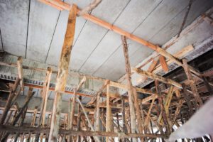 Perspective of structure inside the house under construction. Concrete ceiling and installation of water supply system