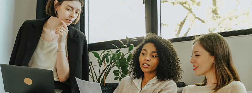 Three women working on participation programs. 